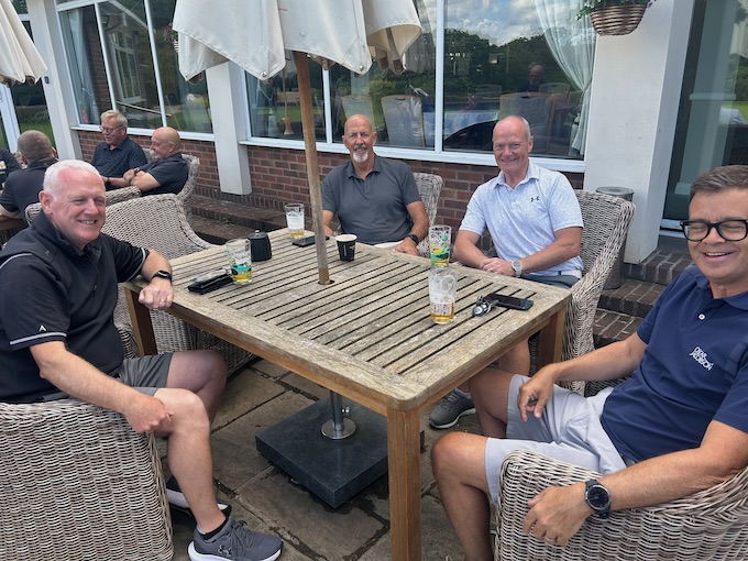 Four members at a terrace table under the parasol